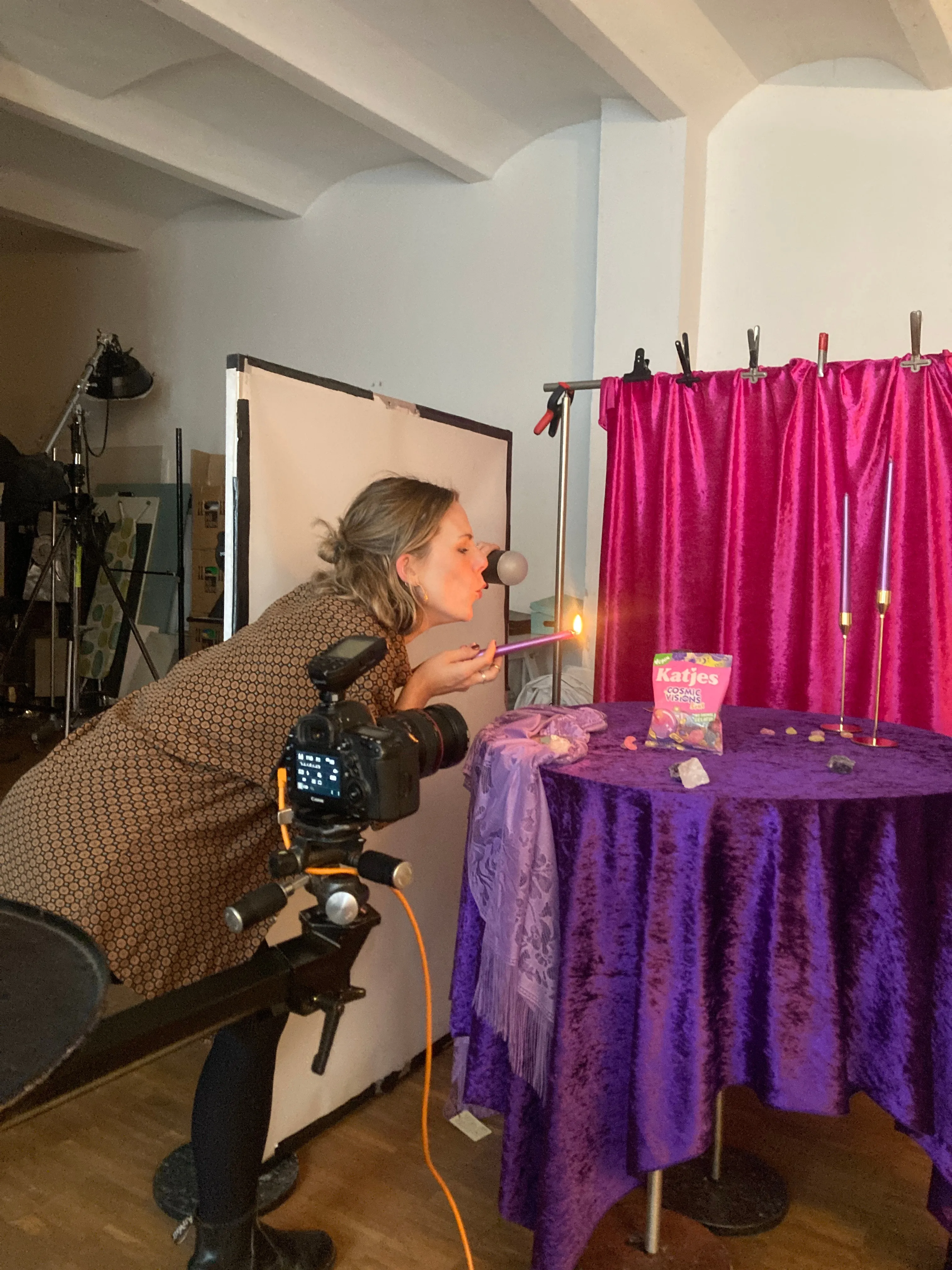 Em Wild behind the camera lighting a Katjes Cosmic Visions sweet pack on a hot pink and purple velvet set